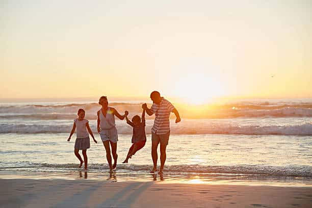 Happy family with their son and daughter at the beach